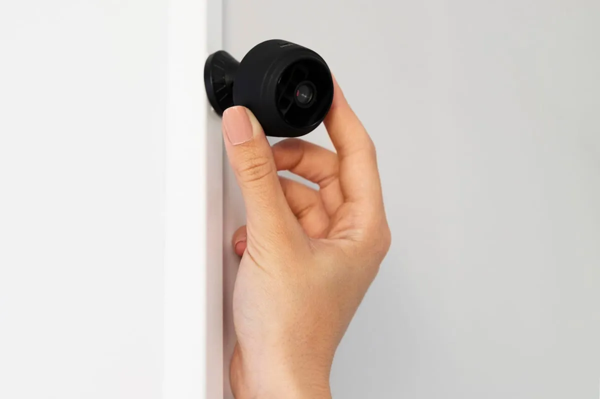 Técnico instalando personalmente una cámara de seguridad en una vivienda